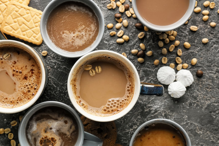 Many cups with tasty aromatic coffee and cookies on grey table, flat layの写真素材