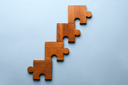 Pieces of wooden puzzle on color backgroundの写真素材