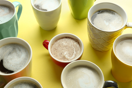 Many cups with tasty aromatic coffee on color backgroundの写真素材