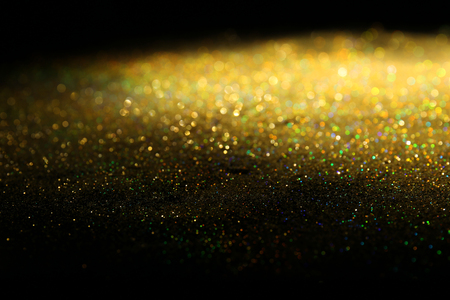 Golden glitters on dark background, closeup