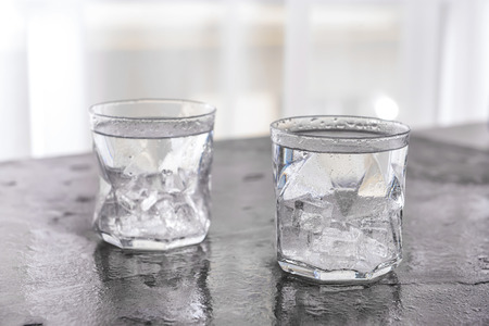Glasses of cold water on grey table