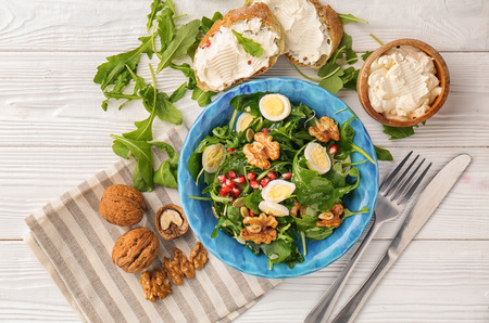 Delicious fresh salad with walnuts on white tableの写真素材