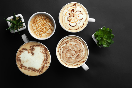 Cups with tasty aromatic coffee on black background, flat layの写真素材