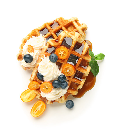 Tasty waffles with fruit, berries and cream on white backgroundの写真素材