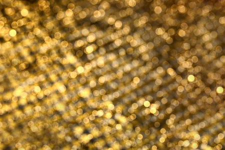Blurred view of shiny golden sequinsの写真素材