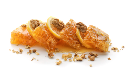Honeycomb, lemon slices and nuts on white backgroundの写真素材