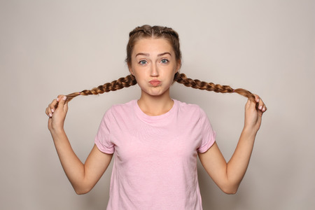 Portrait of funny young woman on light backgroundの写真素材