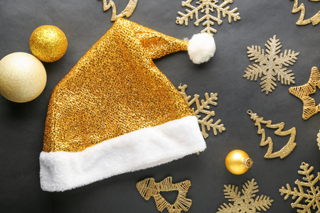 Golden Santa hat with Christmas decorations on black backgroundの写真素材