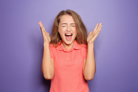 Portrait of screaming young woman on color backgroundの写真素材