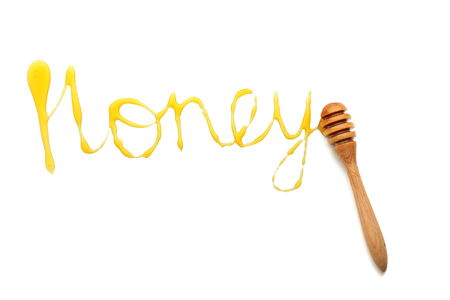 Word HONEY and wooden dipper on white backgroundの写真素材