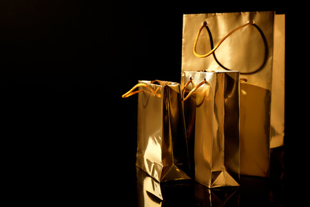 Golden shopping bags on black backgroundの写真素材