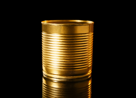 Golden tin can on black backgroundの写真素材