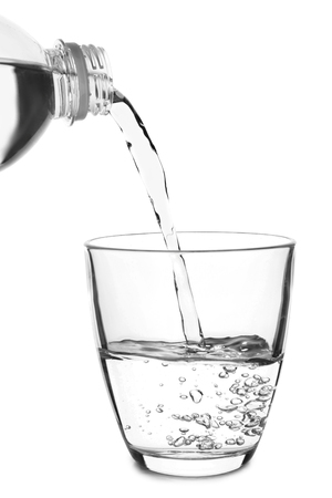 Pouring of water in glass on white backgroundの写真素材