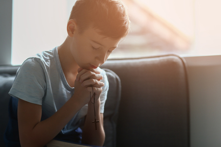 Little boy praying at homeの写真素材