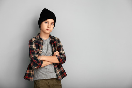 Cute boy in fashionable clothes on color backgroundの写真素材