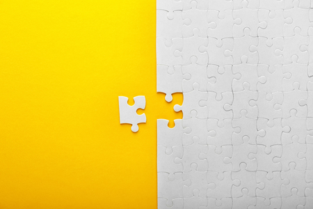 White jigsaw puzzle with piece on color backgroundの写真素材