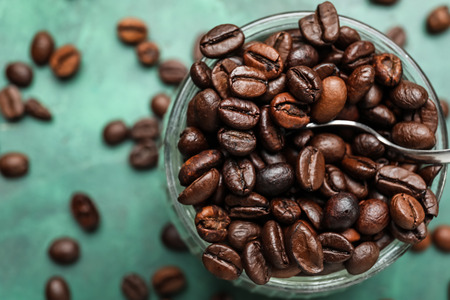 Glass jar with coffee beans on table, closeupの写真素材