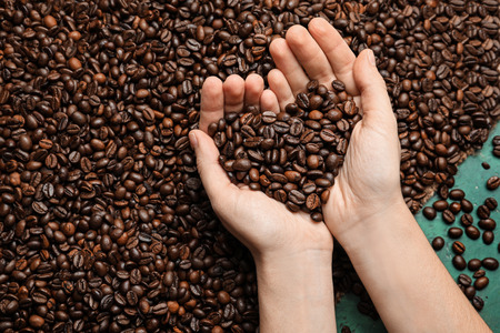 Woman holding roasted coffee beans, closeupの写真素材