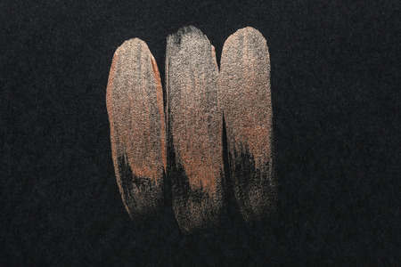 Strokes of gold paint on dark backgroundの写真素材