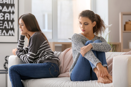 Quarreled young lesbian couple at homeの写真素材