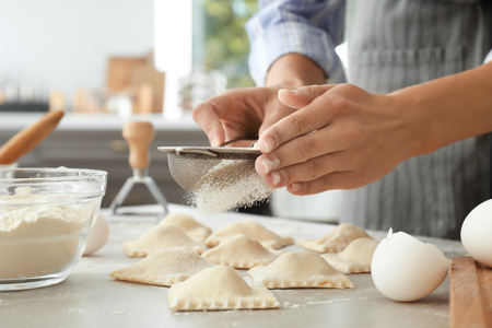 Woman making tasty ravioli on tableの写真素材