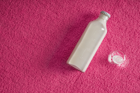 Bottle of milk and pacifier on soft towel, top viewの写真素材