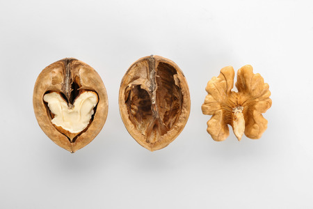 Tasty walnuts with shell on white background