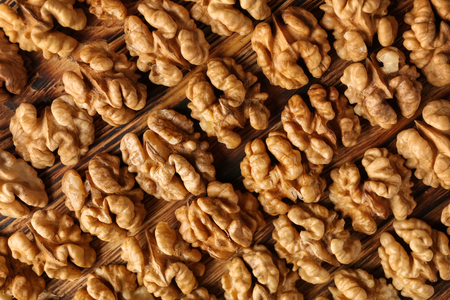 Heap of shelled walnuts on wooden tableの写真素材
