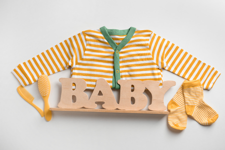 Cute clothes and wooden word BABY on white backgroundの写真素材