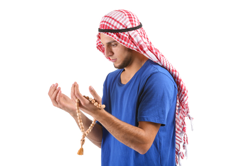 Young Muslim man praying on white backgroundの写真素材