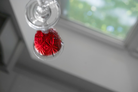 Reflection of glass with wine on table surfaceの写真素材