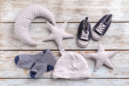Baby clothes and toys on wooden backgroundの写真素材