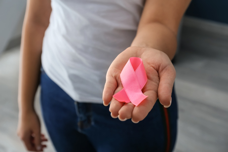 Woman holding pink ribbon, closeup. Breast cancer awareness conceptの写真素材