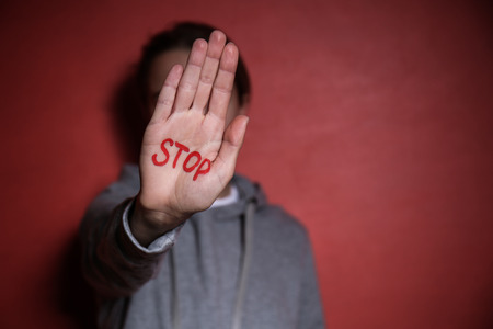 Woman with word STOP written on her palm against color background. Corruption conceptの写真素材