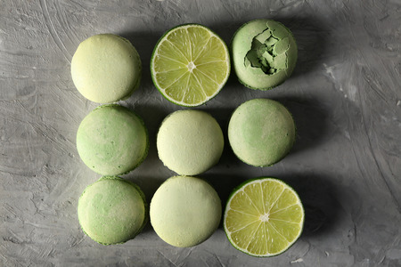 Tasty colorful macaroons with lime on grey tableの写真素材