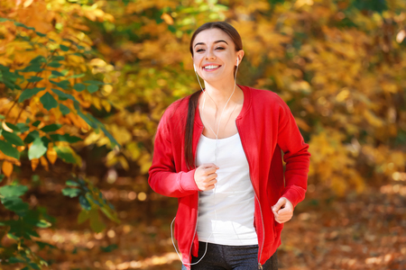 Sporty woman training in park on autumn dayの写真素材