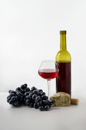 Tasty wine, grapes and cheese on white backgroundの写真素材