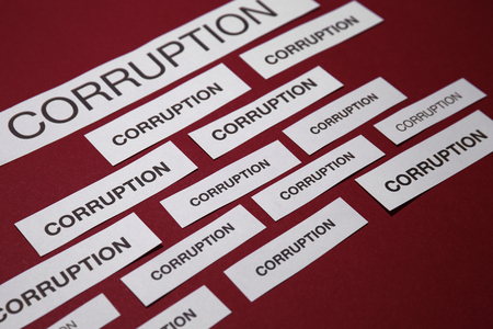 Pieces of paper with words CORRUPTION on red backgroundの写真素材