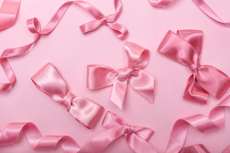 Pink ribbons and bows on color backgroundの写真素材