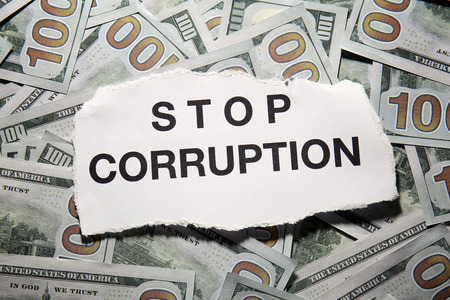 Torn piece of paper with words STOP CORRUPTION on money backgroundの写真素材