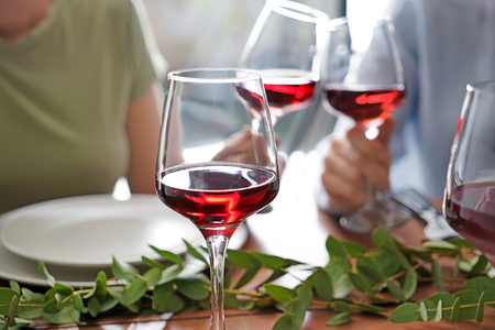 Glass of red wine on table set for partyの写真素材