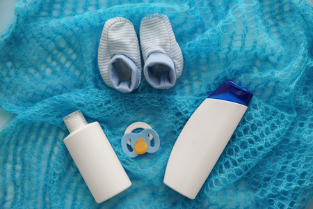 Pacifier with shoes and cosmetics for baby on knitted fabricの写真素材
