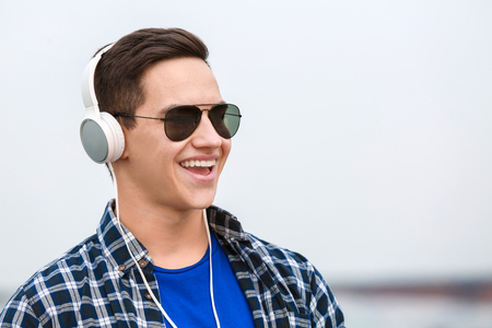 Young man listening to music outdoorsの写真素材