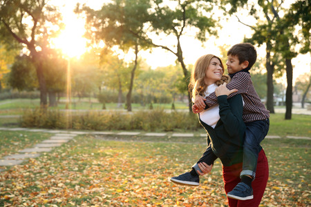 Happy mother and son in autumn parkの写真素材