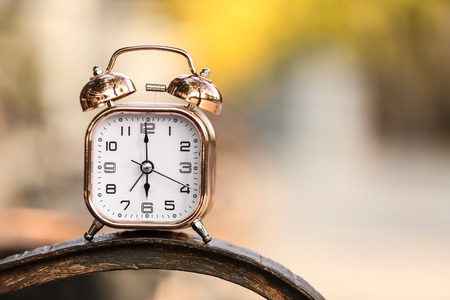 Alarm clock on blurred background outdoors