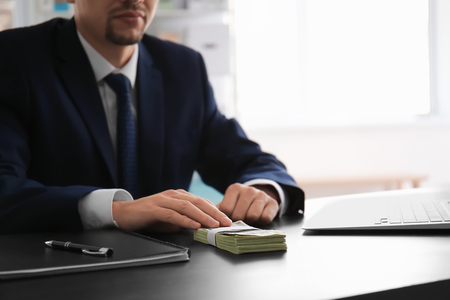 Businessman with bribe at table. Corruption conceptの写真素材