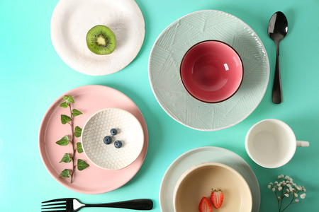 Tableware and cutlery on turquoise background