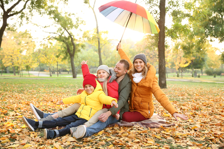 Happy family in autumn parkの写真素材