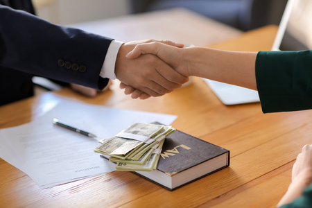 Businessman shaking hands with woman after bribery, closeup. Corruption concept