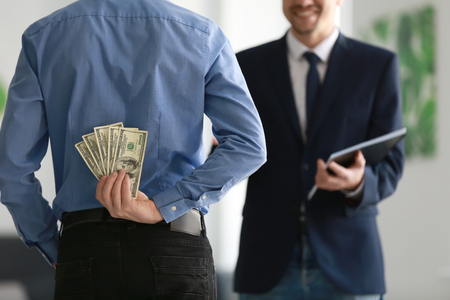 Man holding bribe for businessman behind back. Corruption conceptの写真素材